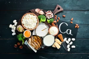 products-containing-natural-calcium-cheese-milk-parmesan-sour-cream-fish-almonds-parsley-garlic-broccoli-black-wooden-background-top-view-free-copy-space187166-1949